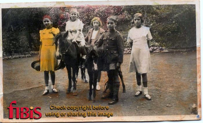 Hand tinted photograph of Five children with two ponies