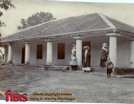 Three women and two children outside a building